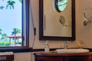 River Kwai House - Bathroom vanity with porthole mirror